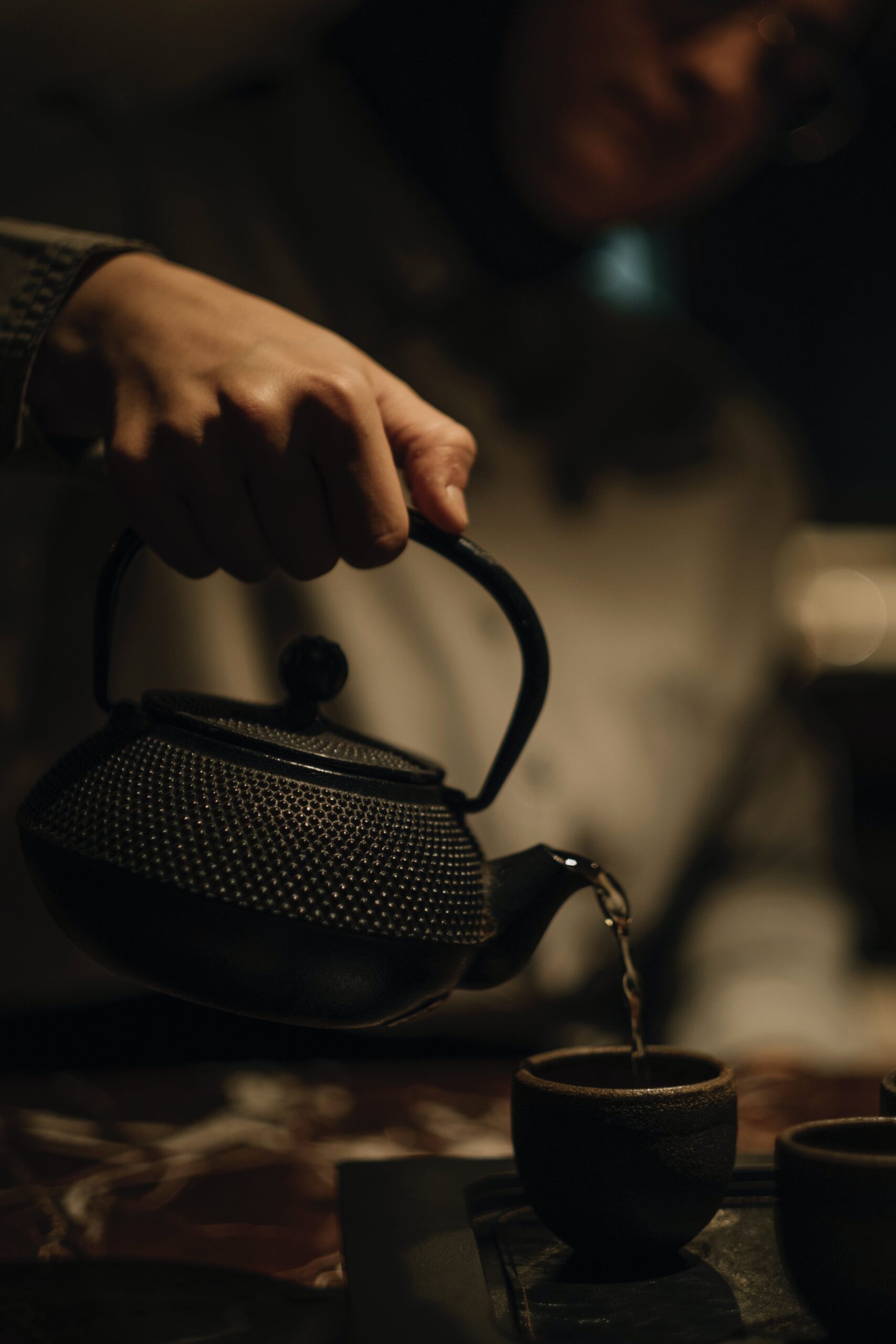 pouring hot tea from a kettle